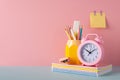 School accessories concept. Photo of stationery on blue desk stand for pens pencils alarm clock stack of notebooks mini stapler Royalty Free Stock Photo