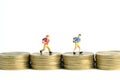 School admission budget. Children or kids, walking above golden coin money stack. Miniature tiny people toys photography.