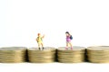 School admission budget. Children or kids, walking above golden coin money stack. Miniature tiny people toys photography.