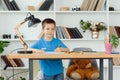 A school-age boy does homework at home. Training at school Royalty Free Stock Photo