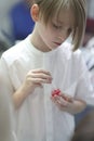 School age boy holding a jar of gel dentifrice