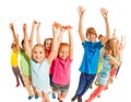 School age kids stand together with raised hands