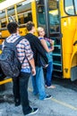 School age teenagers waiting to get on bus Royalty Free Stock Photo