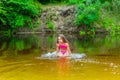 School aged girl. Teenage girl bathes in the river in a pink swimsuit
