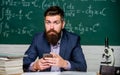 School application. Study technology. School teacher hold mobile phone chalkboard background. Teacher bearded man learn