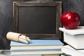 School attributes - black board, books, colored pencils, notebook, apple on dark background. Copy space Royalty Free Stock Photo