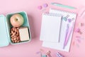School background with notebooks and pastel colorful study accessories on pink background Lunch box with apple, sandwich