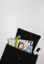 School background. Office supplies in an open black backpack. White background, free space for text