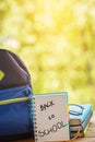 School backpack with books on wooden table and nature background Royalty Free Stock Photo