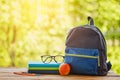 School backpack with books on wooden table and nature background Royalty Free Stock Photo