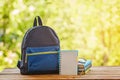 School backpack with books on wooden table and nature background Royalty Free Stock Photo