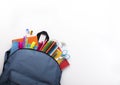 School backpack with colored stationery on white background Royalty Free Stock Photo