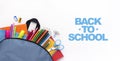 School backpack with colored stationery on white background Royalty Free Stock Photo