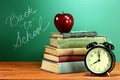 School Books, Apple and Clock on Desk at School