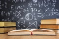 School books on desk infront of blackboard with formulas. education concept Royalty Free Stock Photo