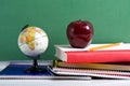 School Books a red Apple and a Globe