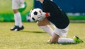 Schoolboy as a soccer goalie catching football ball during a tournament game Royalty Free Stock Photo