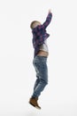School boy in dinsah jumping. Profile view. Full height. White background. Vertical