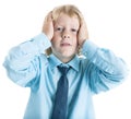 School boy dressed blue shirt and necktie worries while holding his head with hands,  on white background Royalty Free Stock Photo