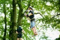 School boy in forest adventure park. Acitve child, kid in helmet climbs on high rope trail. Agility skills and climbing