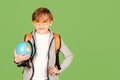 School boy with globe isolated over green background. Smart boy studying geography. Back to school concept