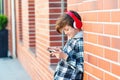 School boy with headphones and smartphone. Student listen music during break. Back to school concept Royalty Free Stock Photo