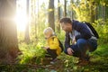 School boy and his father hiking together and exploring nature with magnifying glass. Child with his dad spend quality family time Royalty Free Stock Photo