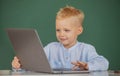 School boy learn lesson sitting at desk, studying online e-learning use internet. Genius child programming, computer