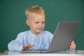 School boy learn lesson sitting at desk, studying online e-learning use internet. Genius child programming, computer