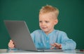 School boy learn lesson sitting at desk, studying online e-learning use internet. Genius child programming, computer