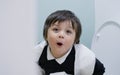 School boy playing with tiolet rolls  while learning how to clean him self, Healthy child happy sitting in the toilet on his own a Royalty Free Stock Photo