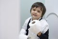 School boy playing with tiolet rolls  while learning how to clean him self, Healthy child happy sitting in the toilet on his own a Royalty Free Stock Photo