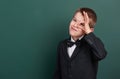 School boy show ok sign, portrait near green blank chalkboard background, dressed in classic black suit, one pupil, education conc Royalty Free Stock Photo