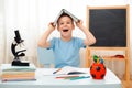 School boy sitting at home classroom lying desk filled with books training material schoolchild sleeping lazy bored Royalty Free Stock Photo