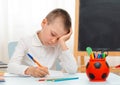 School boy sitting at home classroom lying desk filled with books training material schoolchild sleeping lazy bored Royalty Free Stock Photo