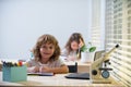 School boy sitting at the table, writing homework or preparing for the exam. Child study. Little studen learning. Royalty Free Stock Photo