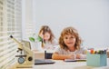 School boy sitting at the table, writing homework or preparing for the exam. Child study. Little studen learning. Royalty Free Stock Photo