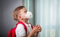 School boy stay at home in face mask for protect coronavirus covid-19. Child pray God and asking for protection. Church Royalty Free Stock Photo