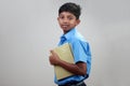 A school boy wearing uniform holds note books in hand Royalty Free Stock Photo