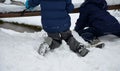 School boy in winter clothes playing in the snow. sometimes he lies on the ground on his back and rests. they risk getting cold an