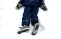 School boy in winter clothes playing in the snow. sometimes he lies on the ground on his back and rests. they risk getting cold an