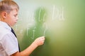 School boy writes English alphabet with chalk on blackboard Royalty Free Stock Photo