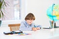 School boy writing his homework at white desk Royalty Free Stock Photo