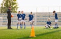 School Boys on Soccer Pitch. Young Coach Talking to Football Players During Training Session Royalty Free Stock Photo