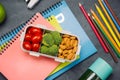 School breakfast on desk with books and pen on board background