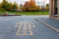 School building and school yard with hopscotch and playground for elementary students in evening in fall season Royalty Free Stock Photo