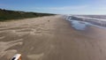 School bus converted into camper alone on beach by ocean