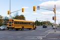 School bus on road in Ottawa city passing traffic lights at intersection