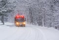 School Bus Travelling on a Snow Covered Rural Road with Stop Lights Flashing Royalty Free Stock Photo