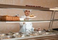 School canteen worker with burger at serving line